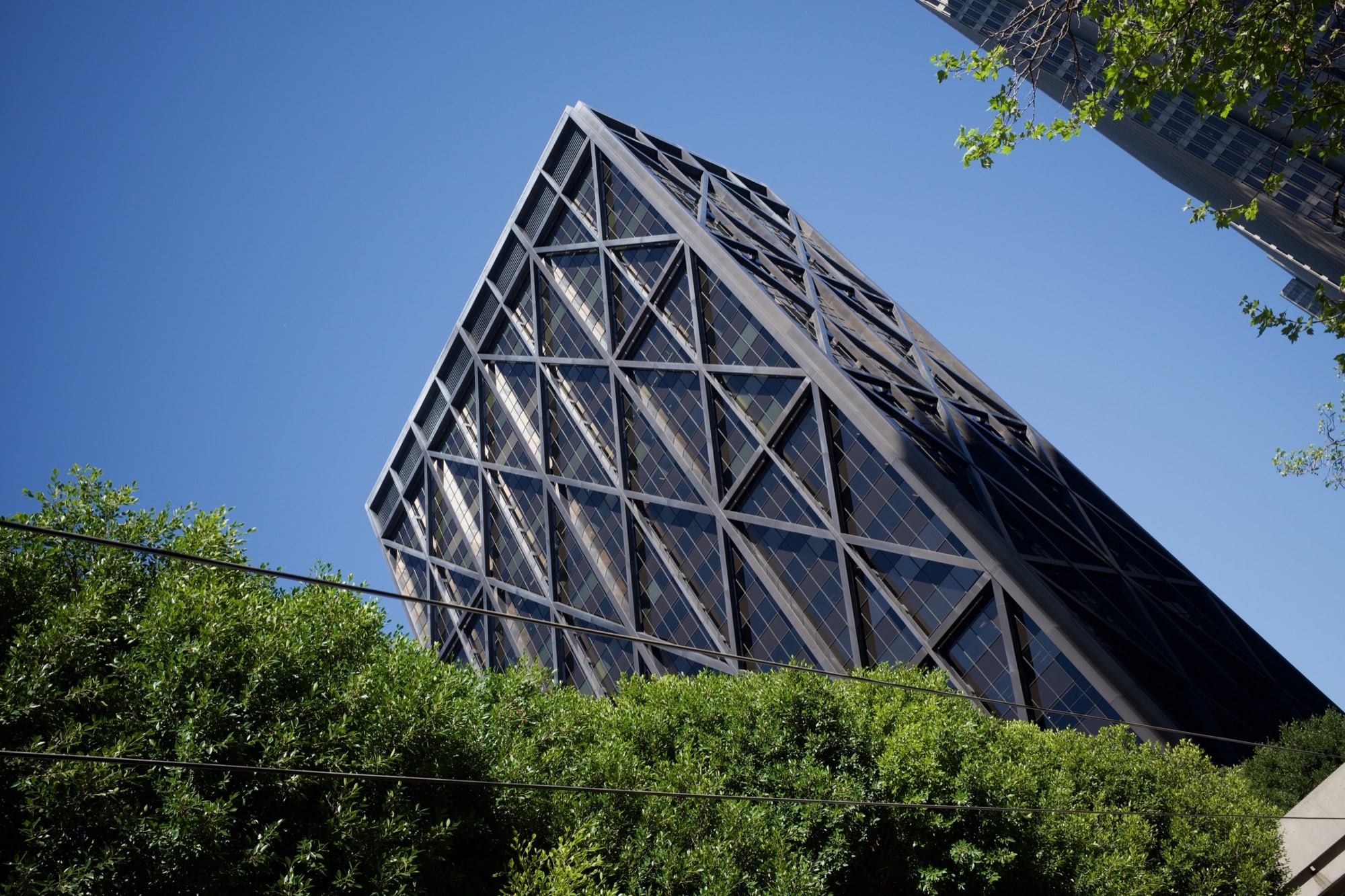 A black tower captured diagonally, with shimmery refractions of sunlight