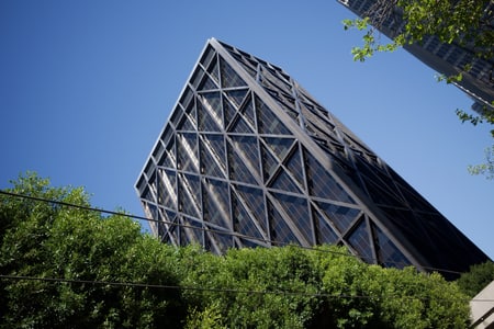 A black tower captured diagonally, with shimmery refractions of sunlight