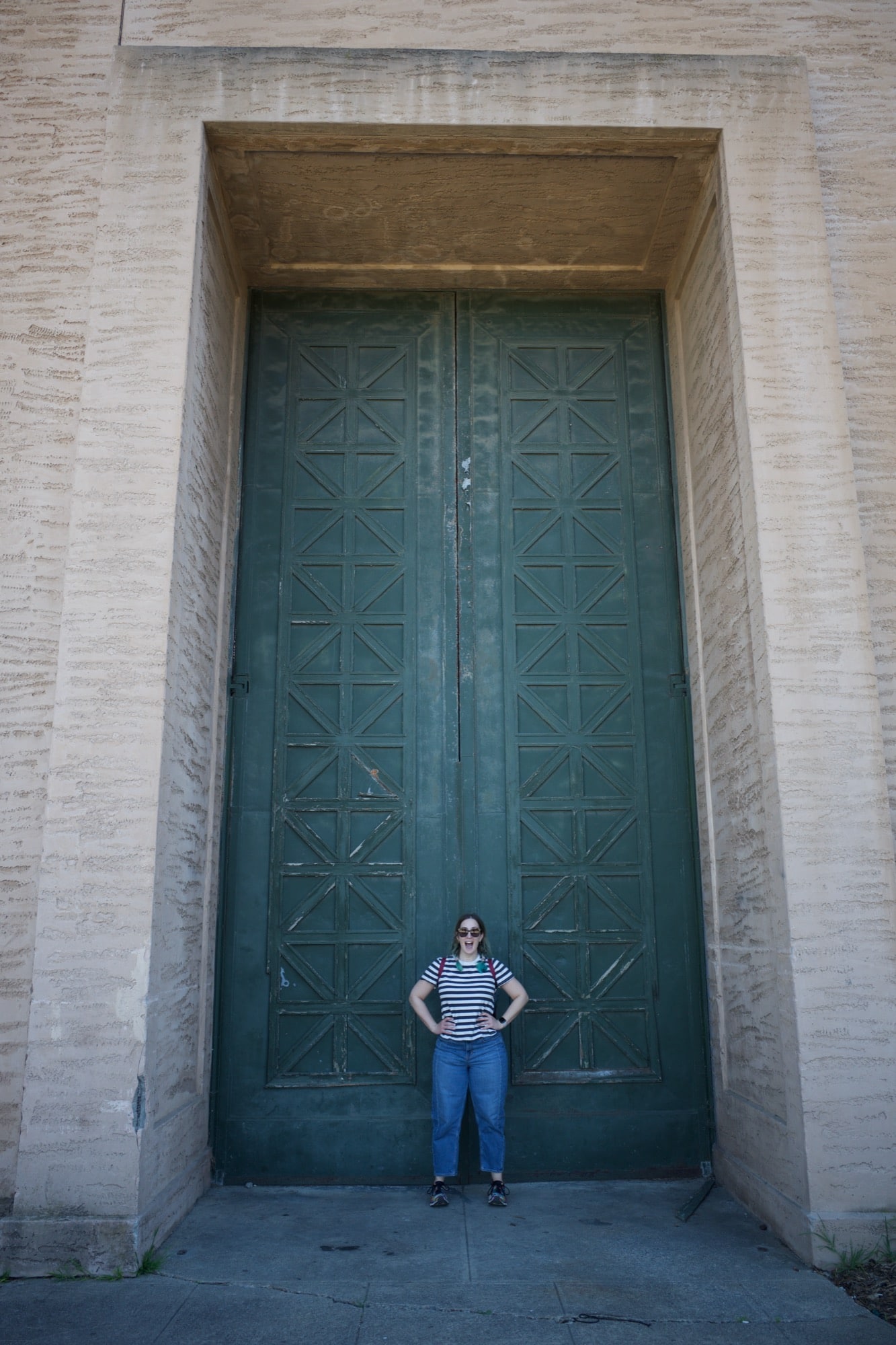 Molly stands in front of giant green doors at the Palace of Fine Arts