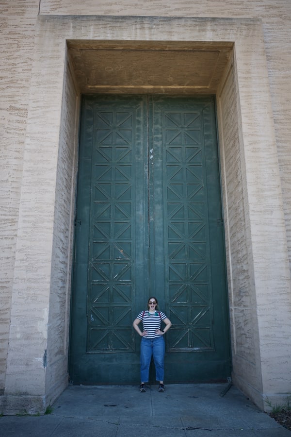 Molly stands in front of giant green doors at the Palace of Fine Arts