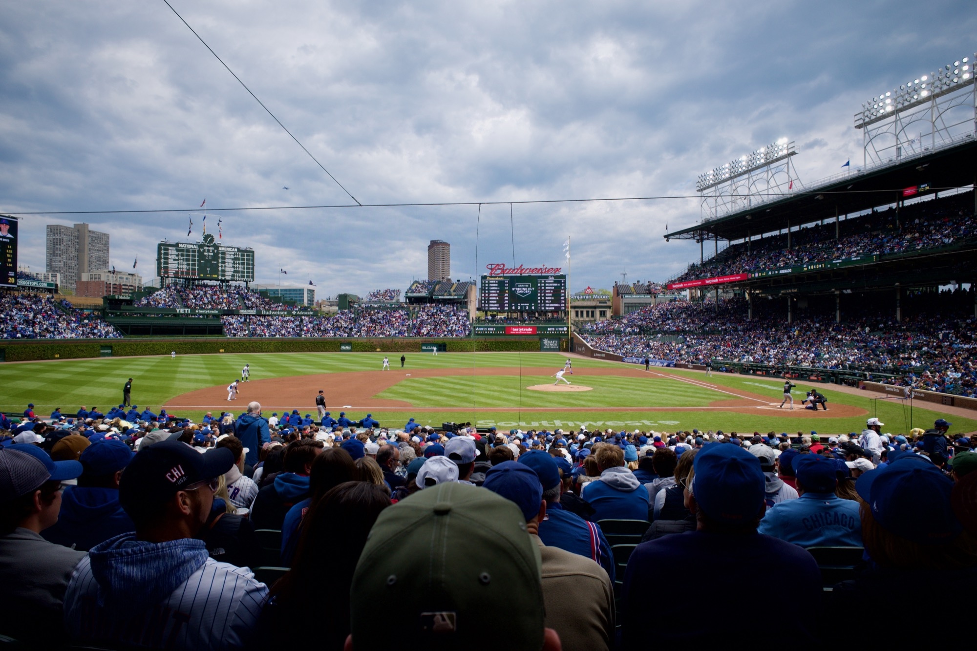 A wide view from the stands as a pitcher for the Cubs is mid-pitch.