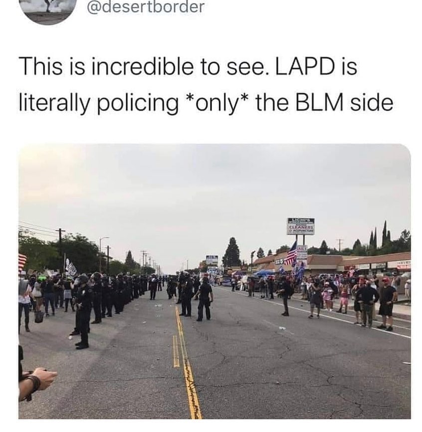 A screenshot of a post on Twitter depicting a photo of police creating a barrier between MAGA protestors and peaceful Black Lives Matter protesters.