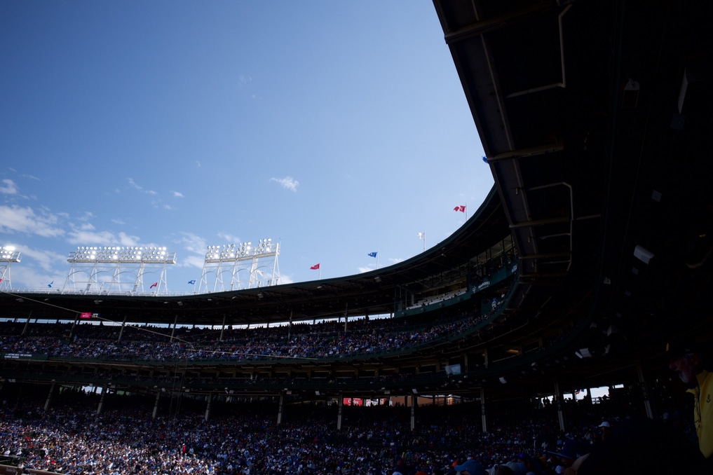 Penant flags waving in the wind along the top of the canopy over the packed stands at Wrigley Field