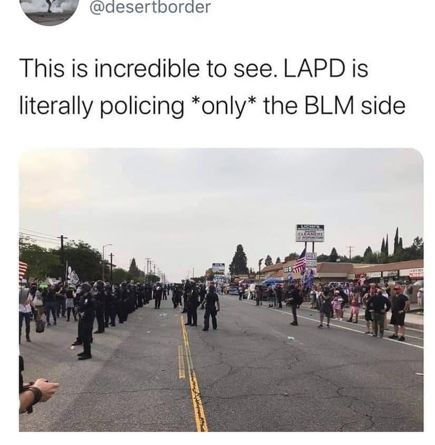 A screenshot of a post on Twitter depicting a photo of police creating a barrier between MAGA protestors and peaceful Black Lives Matter protesters.
